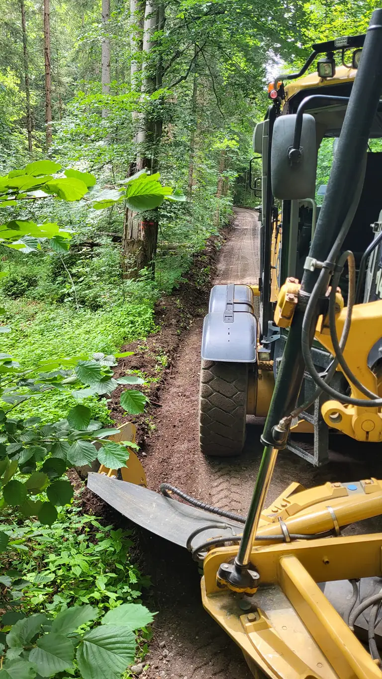 Nahaufnahme Reißzähne eines Graders beim Wegebau